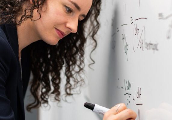 Math MileMarkers® A woman writing on the wall with a marker